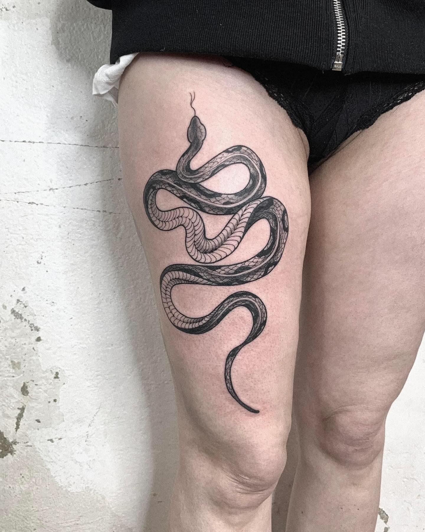 Snake black and grey tattoo on the thigh by Elvira Savchuk