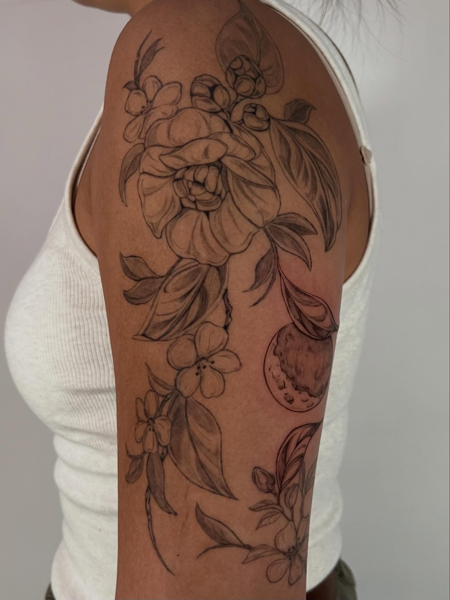 Floral bouquet black and grey tattoo on the upper arm by Sierra Skye