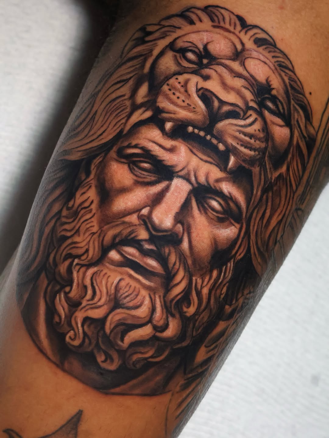 Hercules wearing lion skin surrealism tattoo on the forearm by German Patiño.