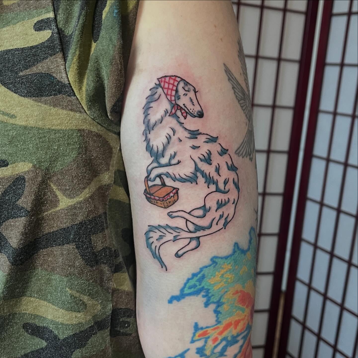 Greyhound with picnic basket new school tattoo on the forearm by madelynne (maddie) caldwell tattoos