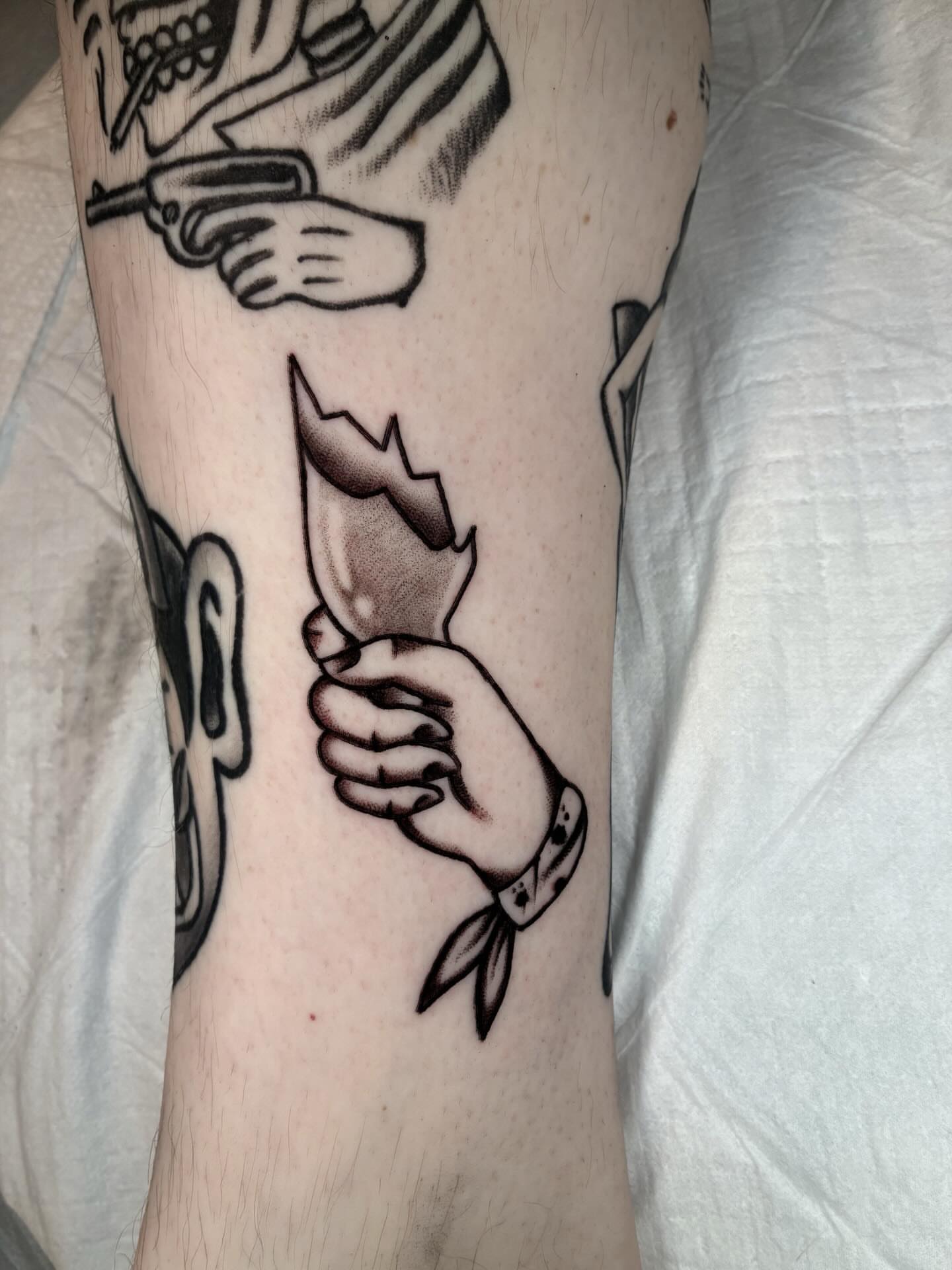 Hand holding paper black and grey tattoo on the forearm by ๐๐ช๐๐ซ๐ก๐ ๐๐ฏ๐ถ๐ฉ๐