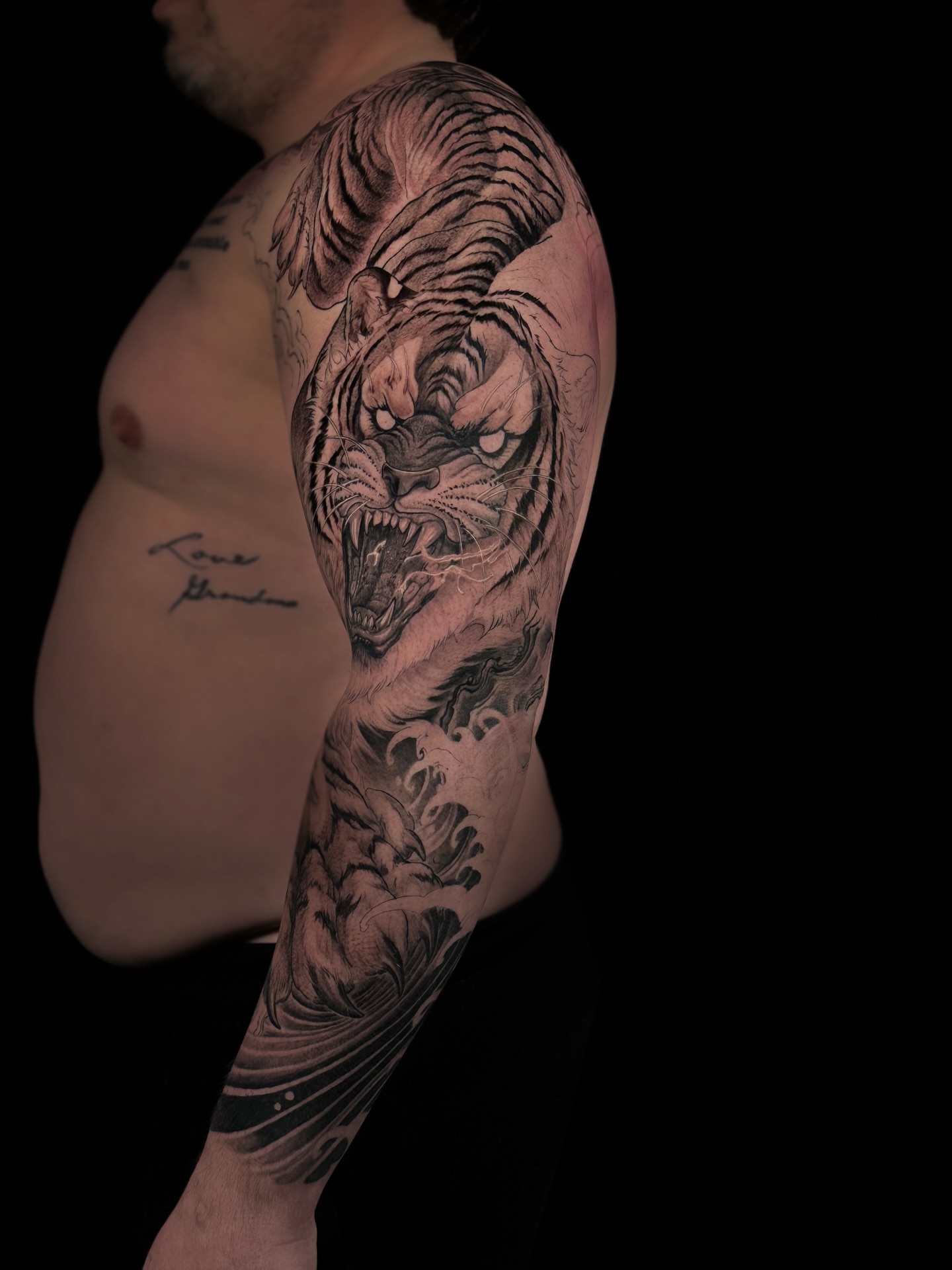 Tiger realism tattoo on the upper arm by Vince Lau