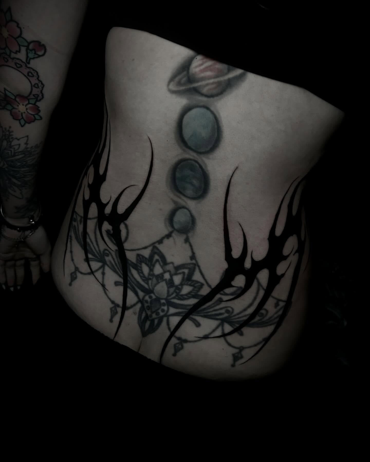 Planets and tribal tribal tattoo on the torso by Heaven Arianna