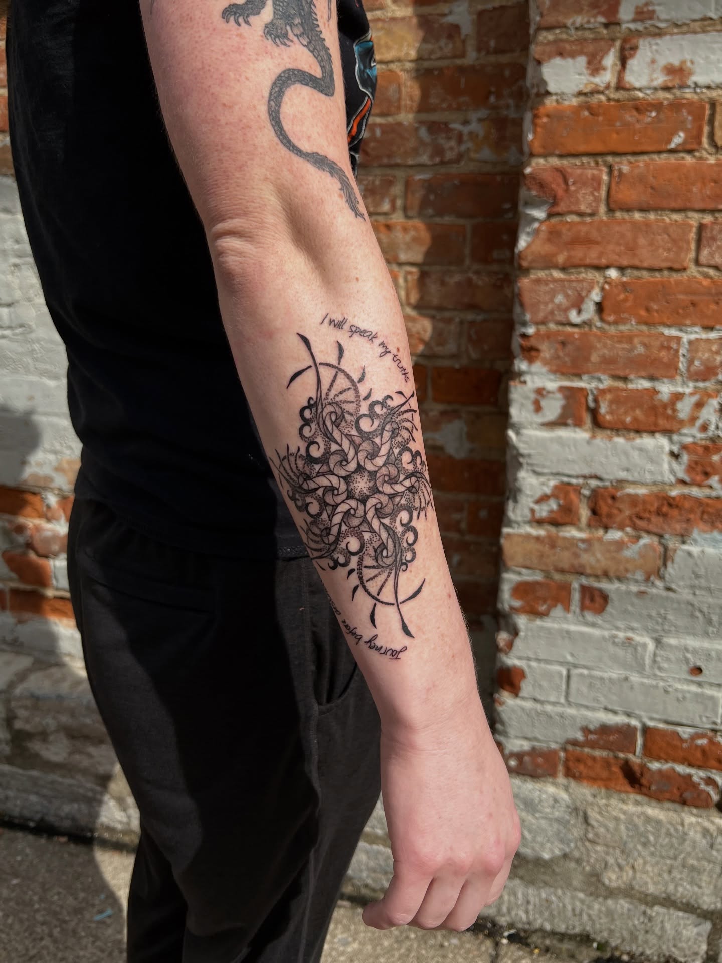Mandala black and grey tattoo on the forearm by Riley