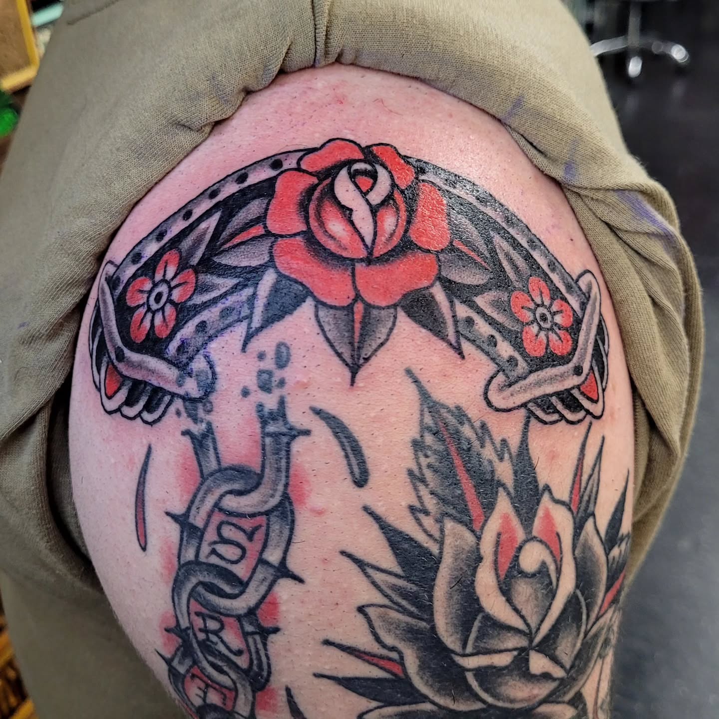 Rose and horseshoe American traditional tattoo on the shoulder by S. Madrid