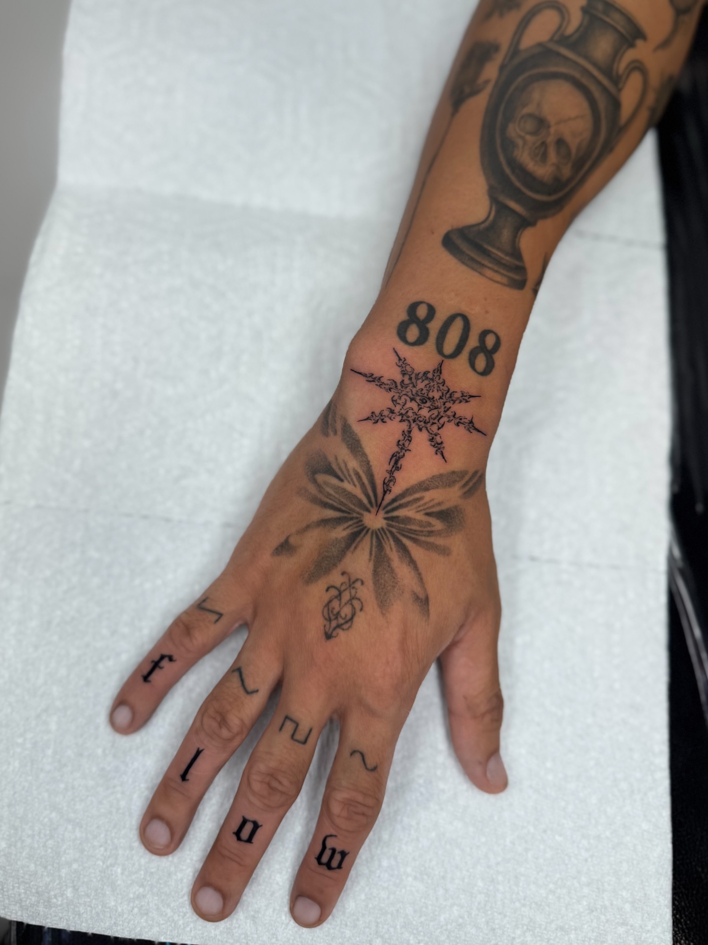Hand with multiple tattoos black and grey tattoo on the hand by Miami Tattoo Artist, Miami, Florida