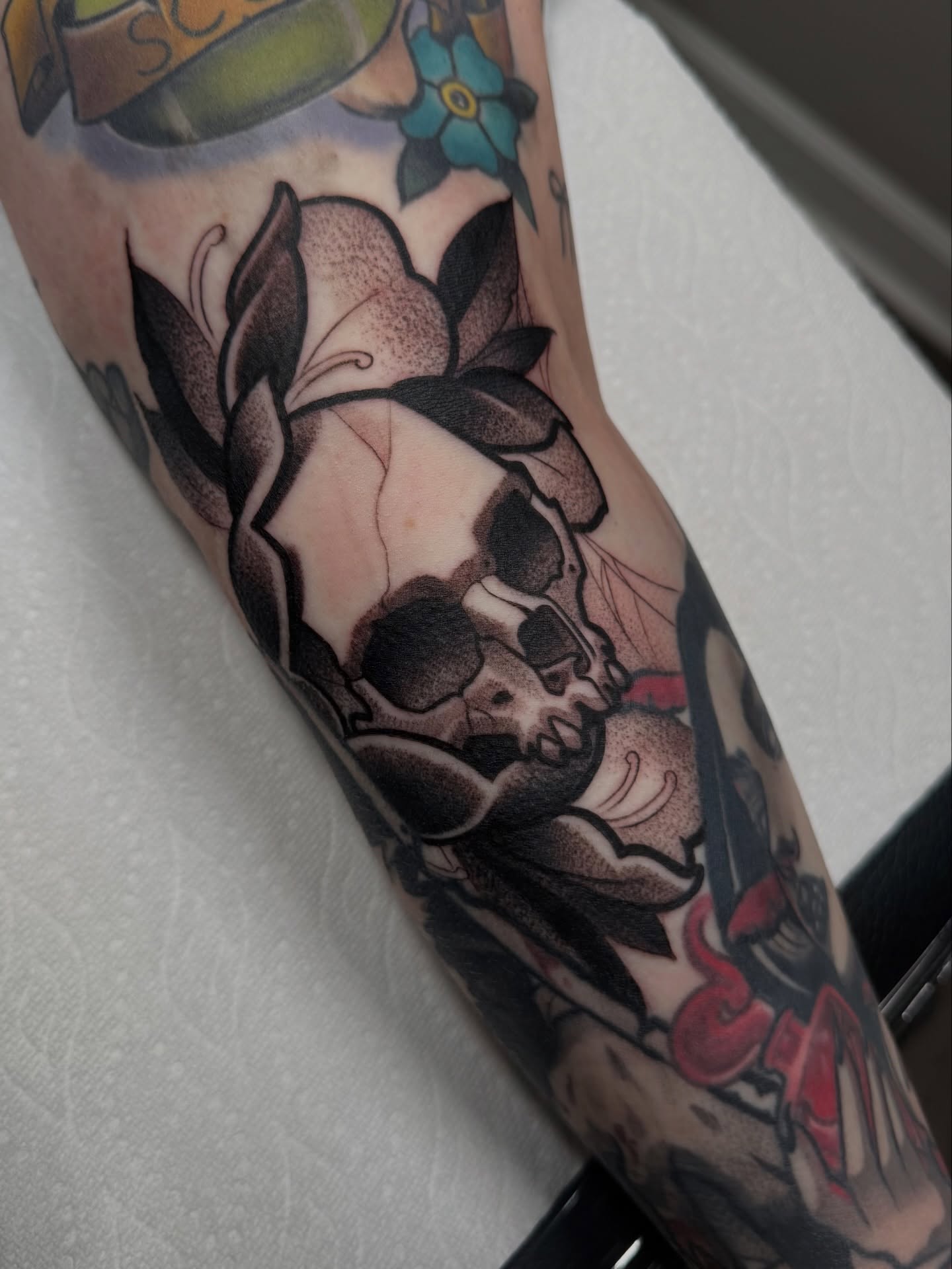 Skull and roses American traditional tattoo on the forearm by Jake lyon