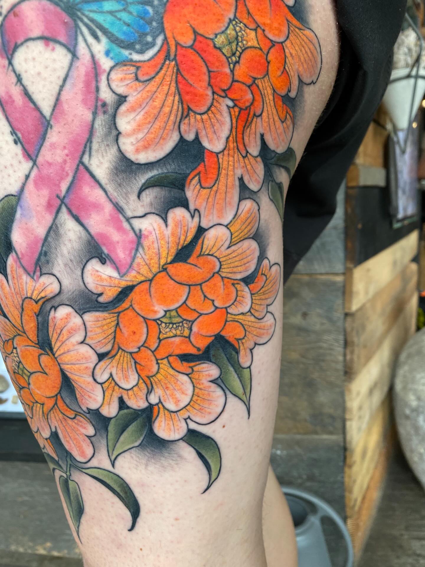 Orange flowers new school tattoo on the forearm by Kyle Kozek, Columbus, Ohio