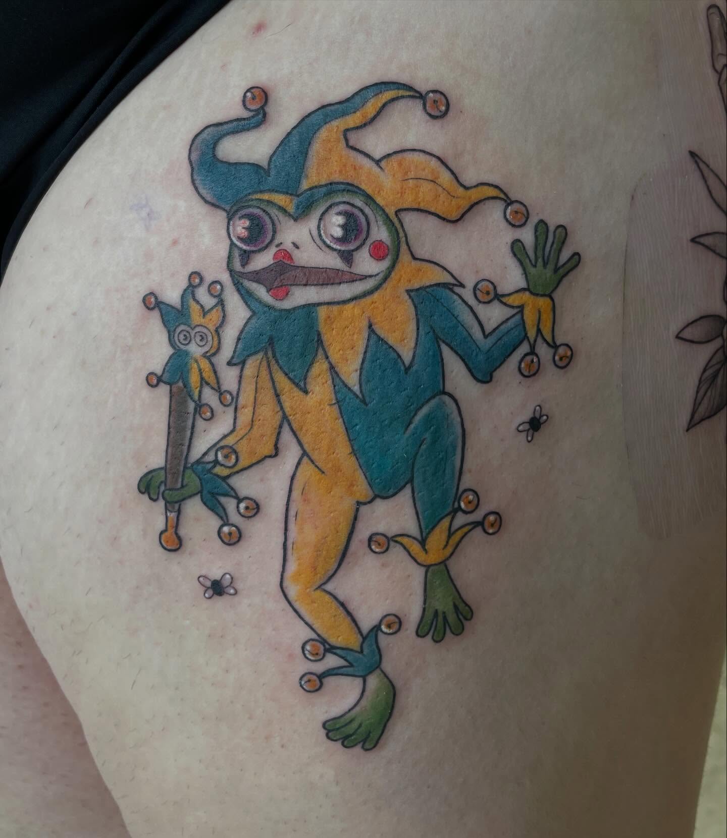 Jester frog trash polka tattoo on the thigh by Stevie Timmreck, Utica, Michigan