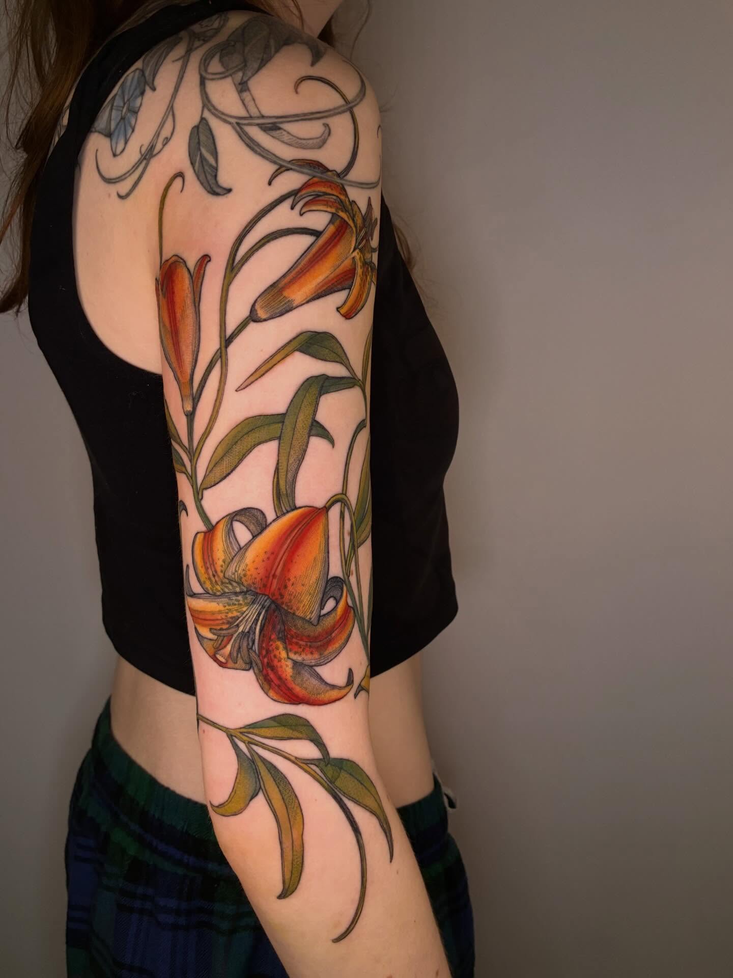 Lilies realism tattoo on the forearm by Carol Jacky
