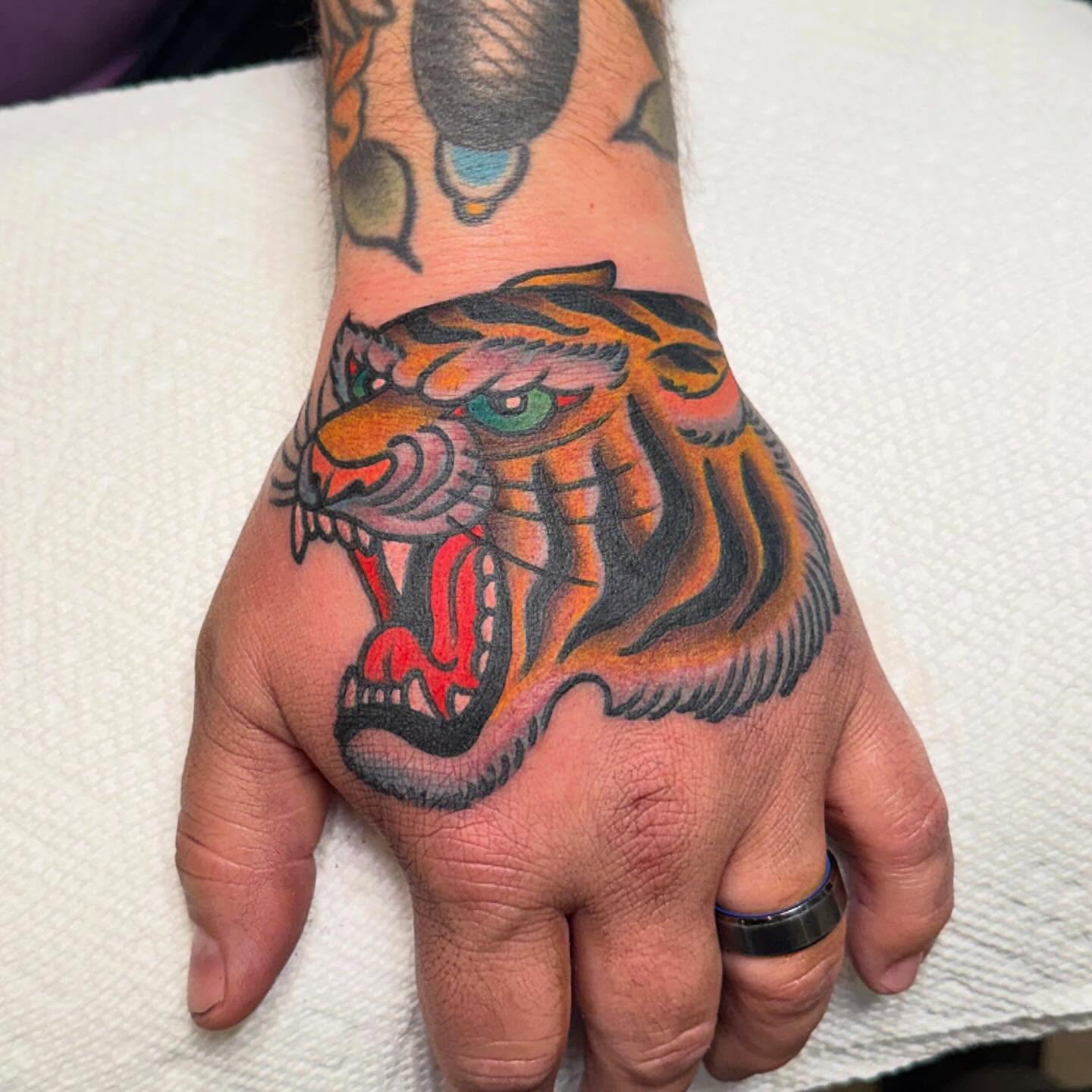 Tiger American traditional tattoo on the hand by Zach Roman, Madison, Wisconsin