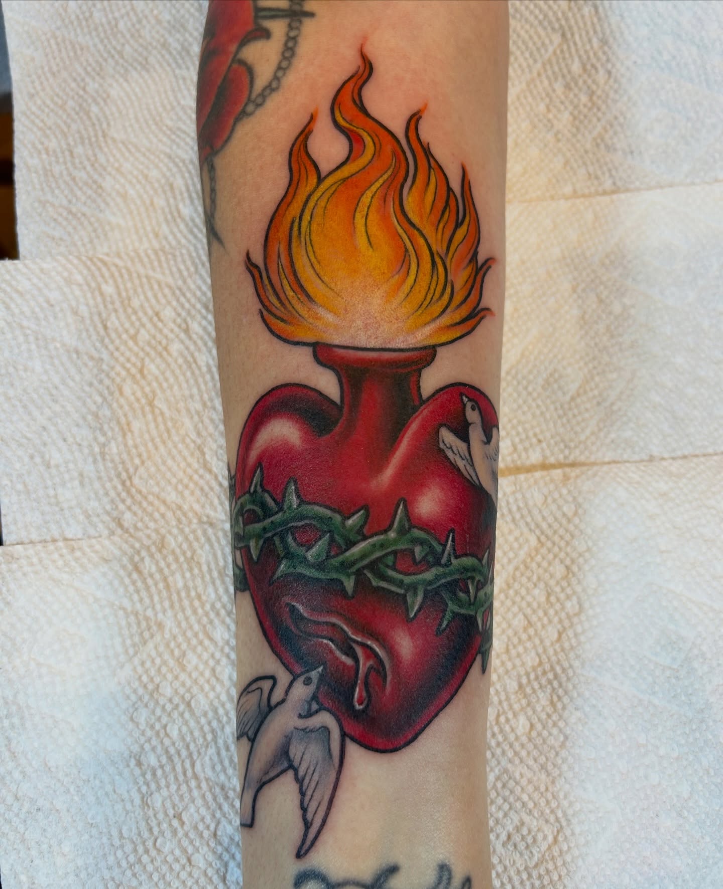 Flaming heart American traditional tattoo on the forearm by Justin Weatherholtz, New York, New York