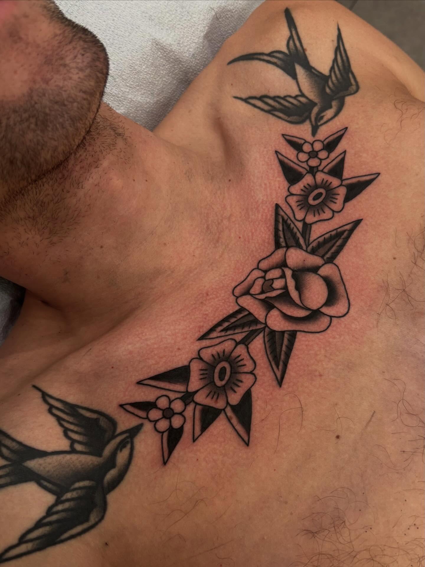Swallow and floral bouquet American traditional tattoo on the chest by Claire Anderson