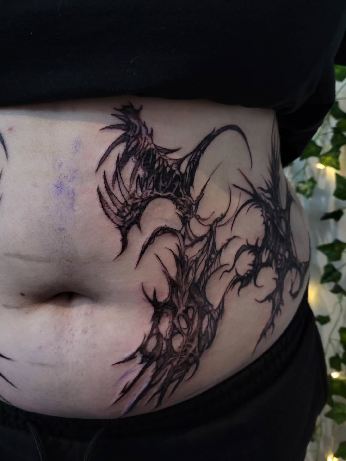 Dragon black and grey tattoo on the torso by Uku Tattoos, Cambridge, England