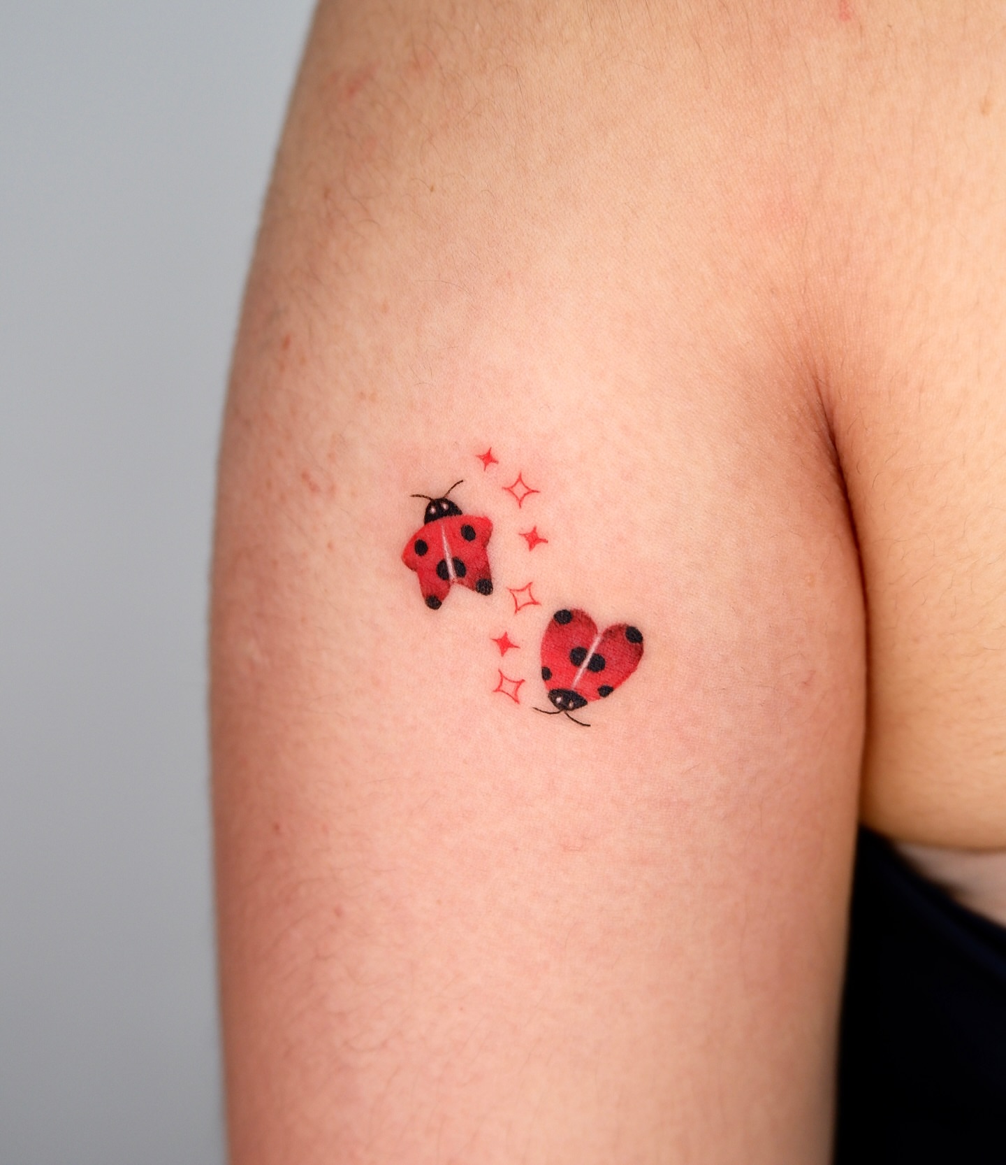 Ladybugs dotwork tattoo on the upper arm by 타투 Seon 컬러타투