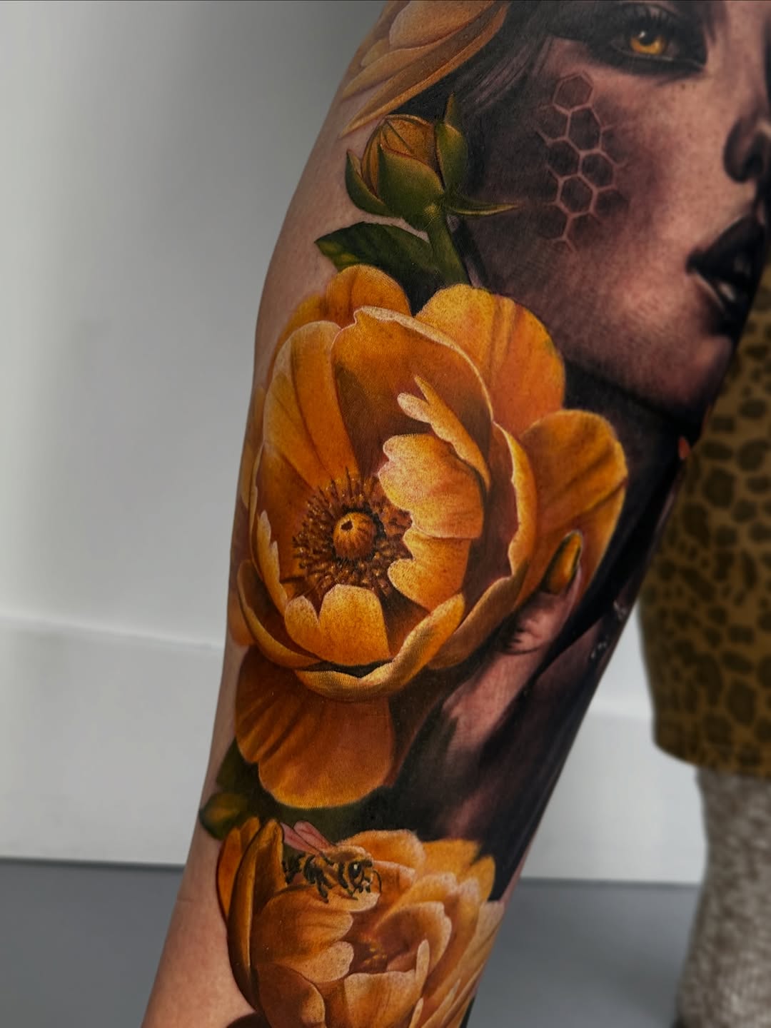 Woman with flowers and bee neo-traditional tattoo on the forearm by Dakota Case