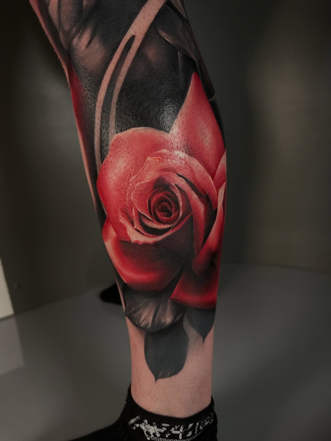 Red rose neo-traditional tattoo on the forearm by Dakota Case