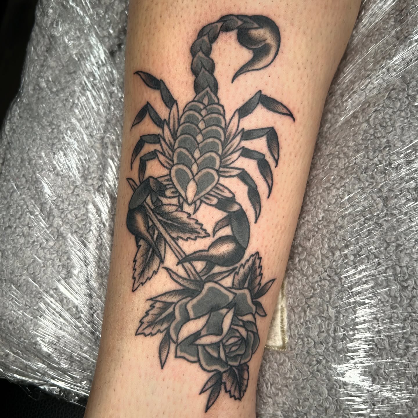 Scorpion and roses black and grey tattoo on the forearm by Audrey Migitsch