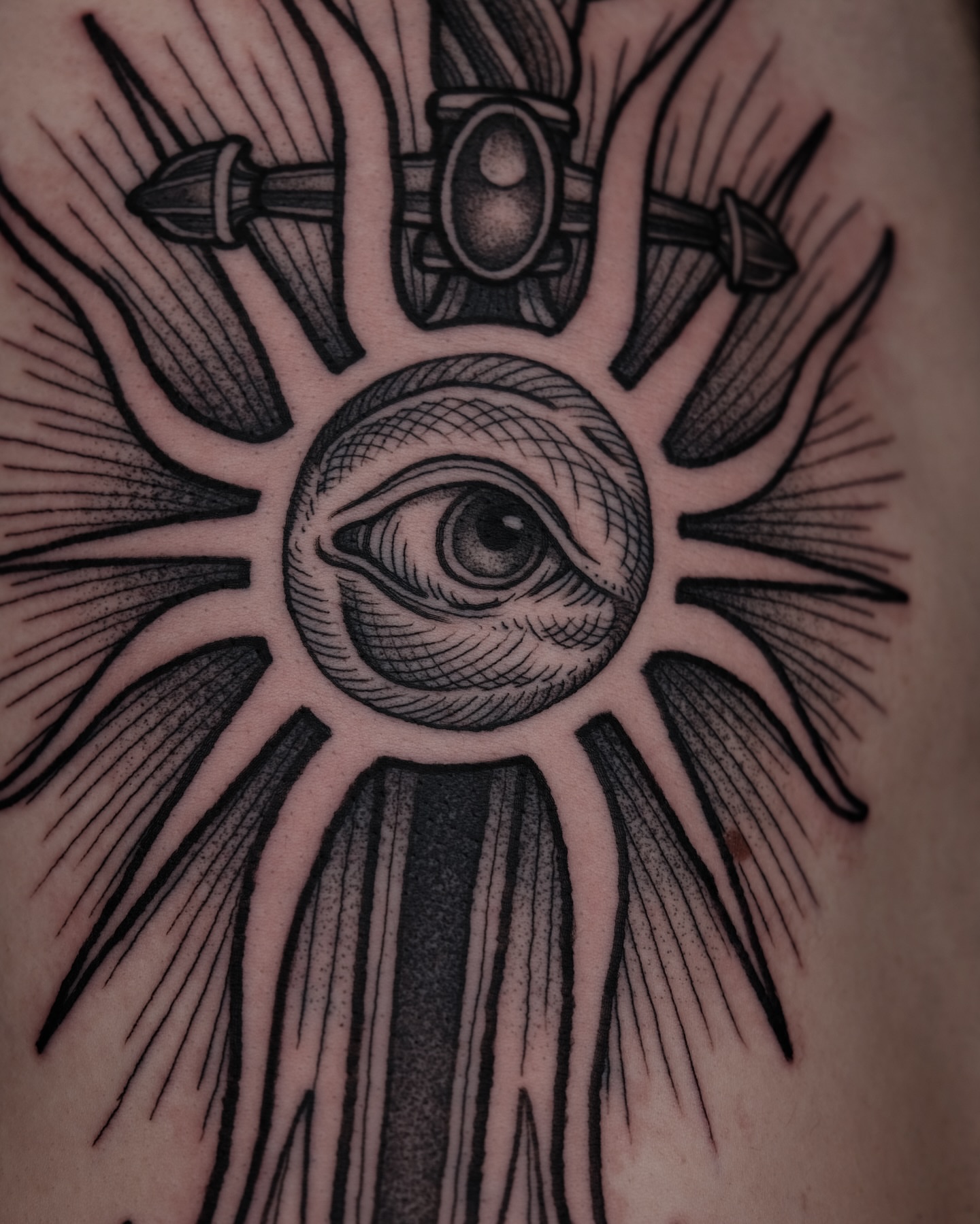Eye and sunburst black and grey tattoo on the forearm by Kyle Patrick