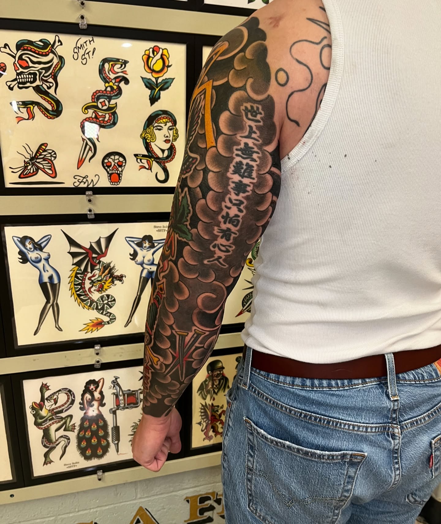 Clouds and kanji American traditional tattoo on the upper arm by Tim Howell
