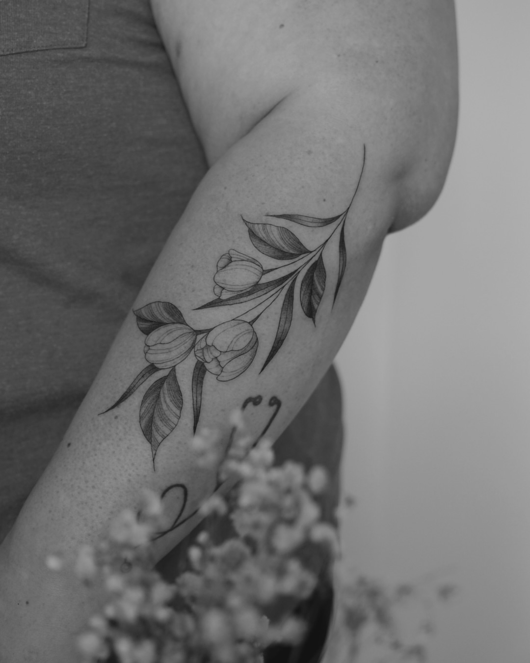 Tulips black and grey tattoo on the forearm by Haley Sayers