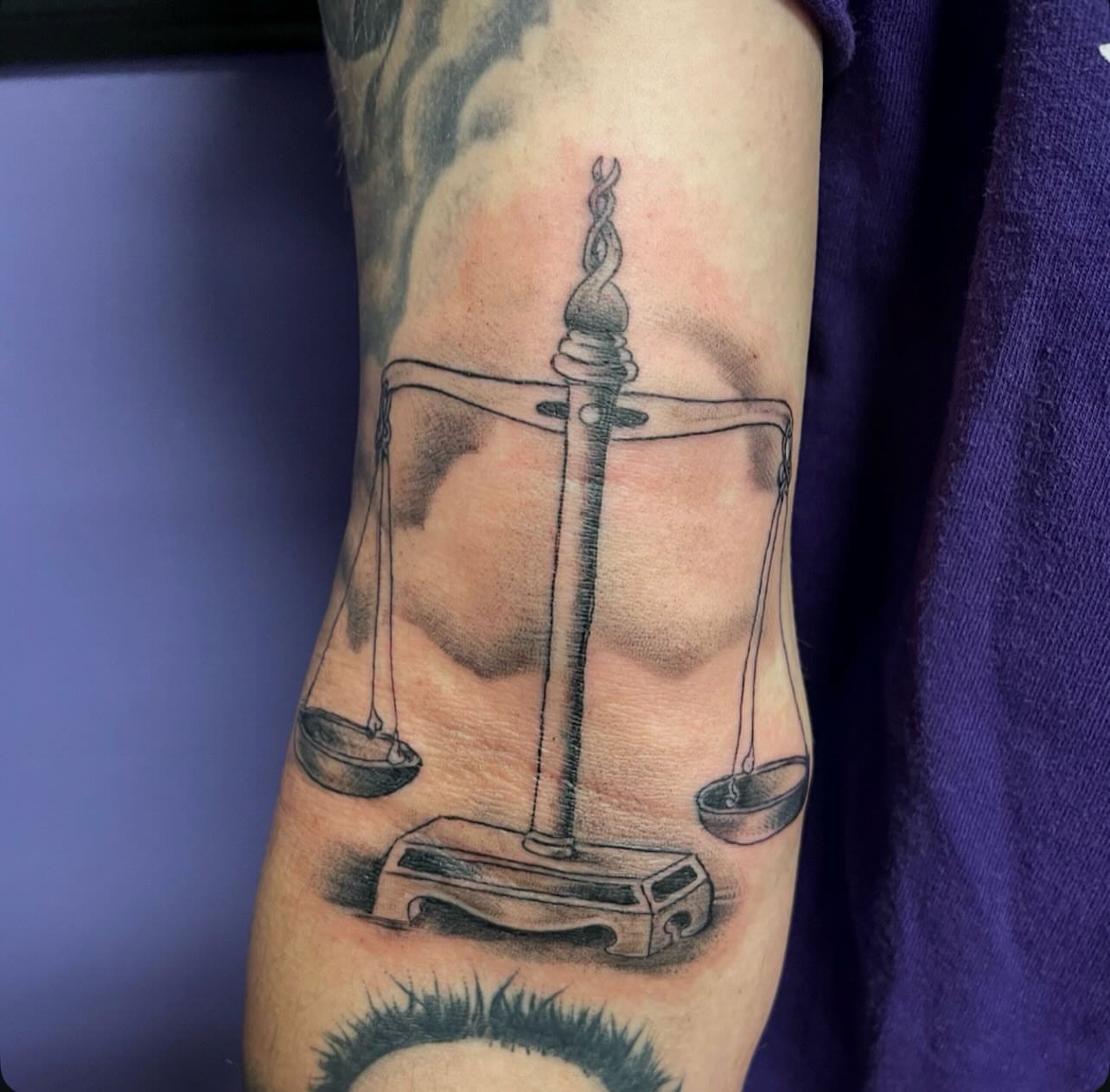 Scale of justice black and grey tattoo on the forearm by Mark Calloway