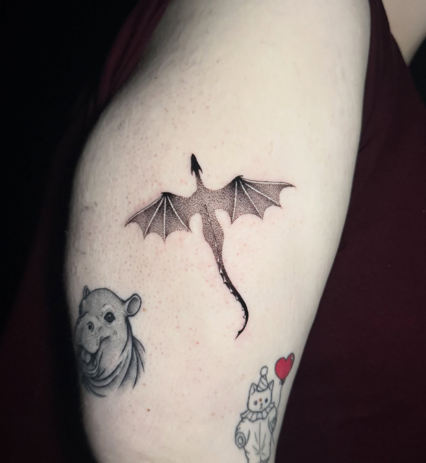 Dragon, hippo, cat dotwork tattoo on the upper arm by Lauren B
