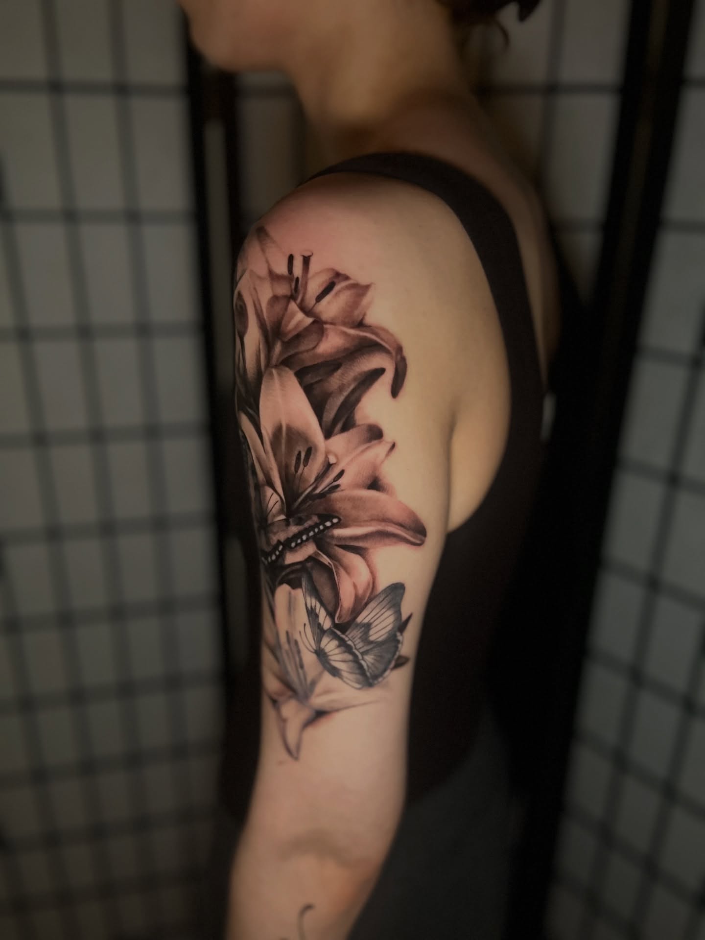 Lilies and butterfly realism tattoo on the forearm by Mant
