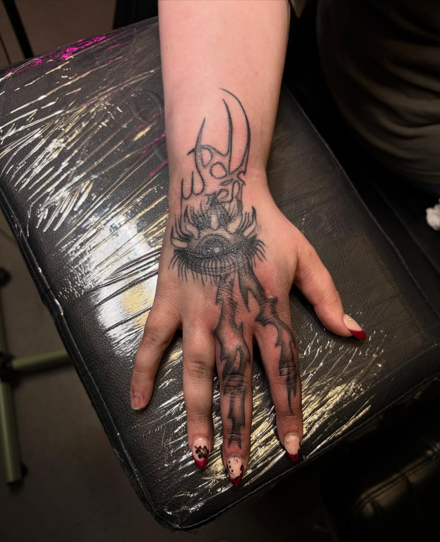 Eye with horns black and grey tattoo on the hand by Melissa