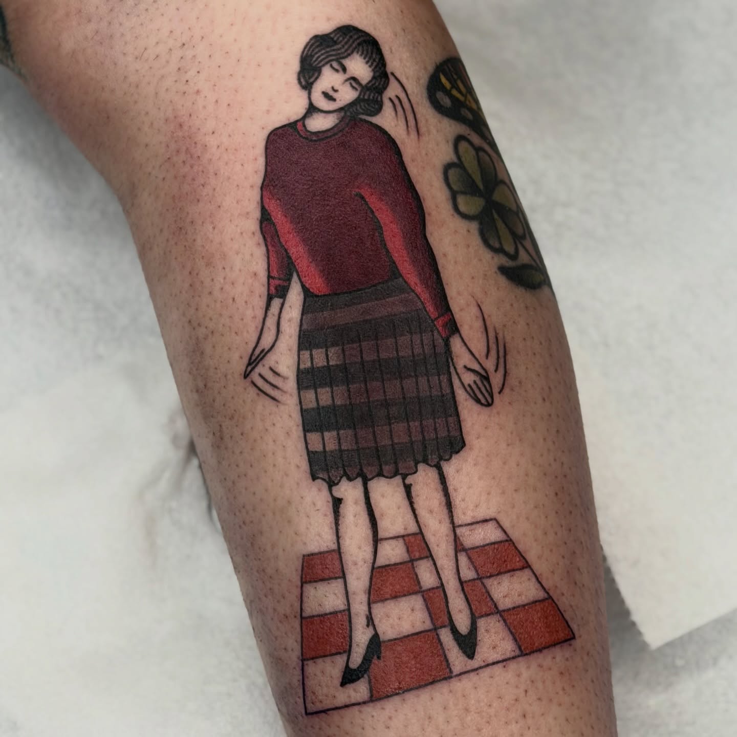 Woman in plaid skirt illustrative tattoo on the forearm by Maks