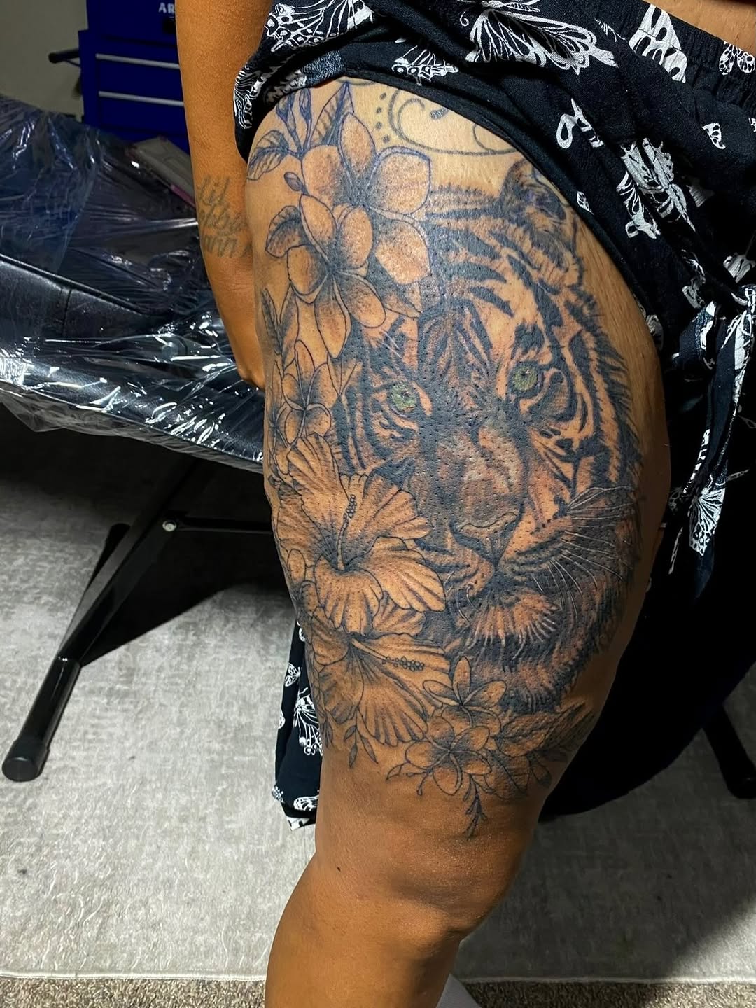Tiger and flowers realism tattoo on the thigh by Jelani