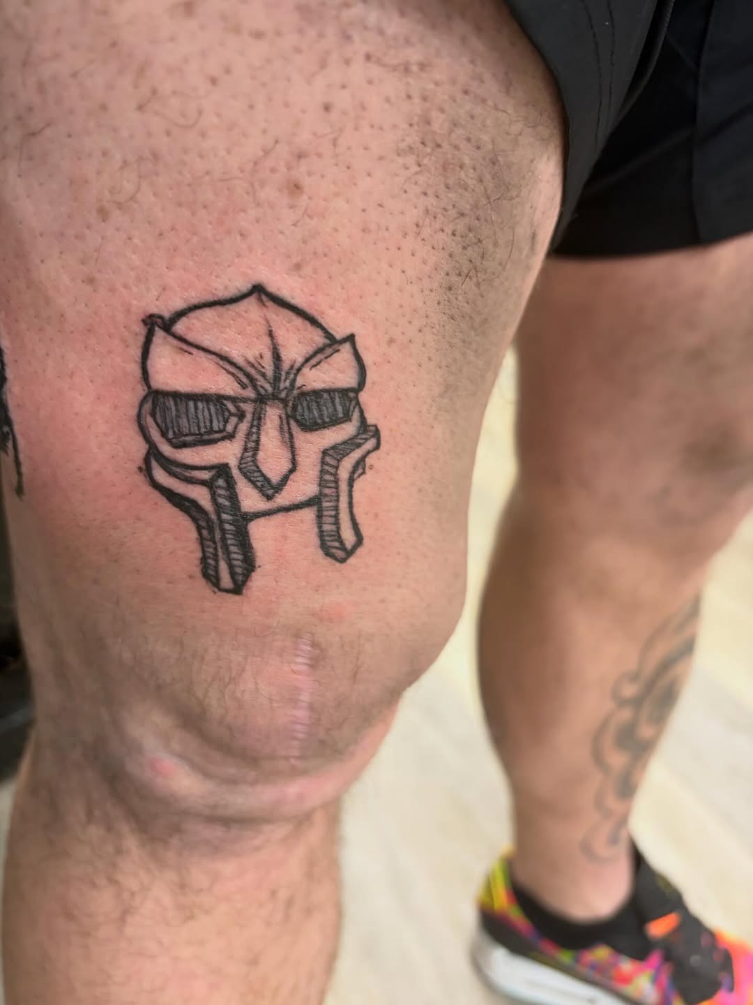 MF Doom mask tattoo on the thigh by Madison