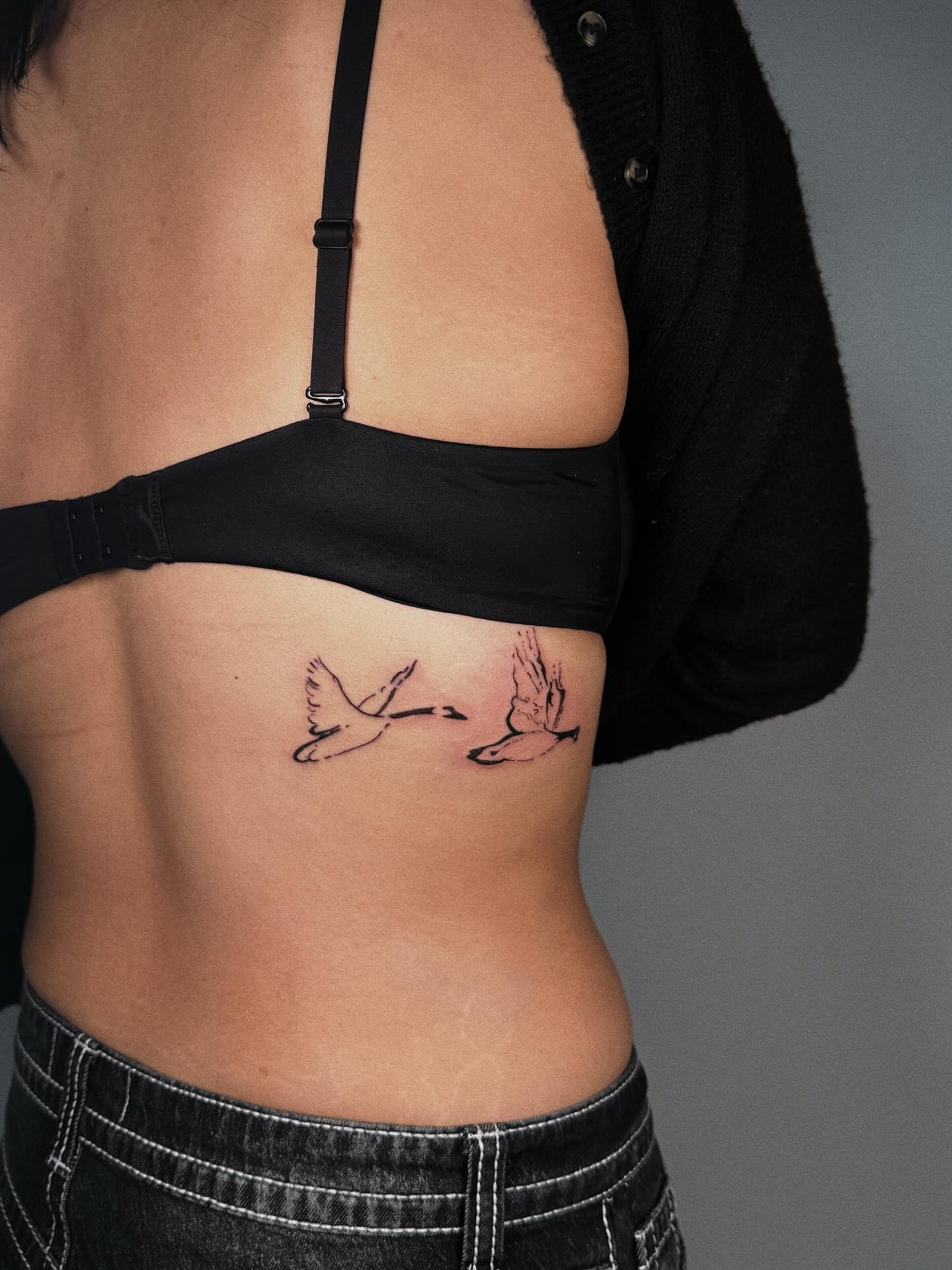 Swans black and grey tattoo on the ribs by Paulina Vazquez
