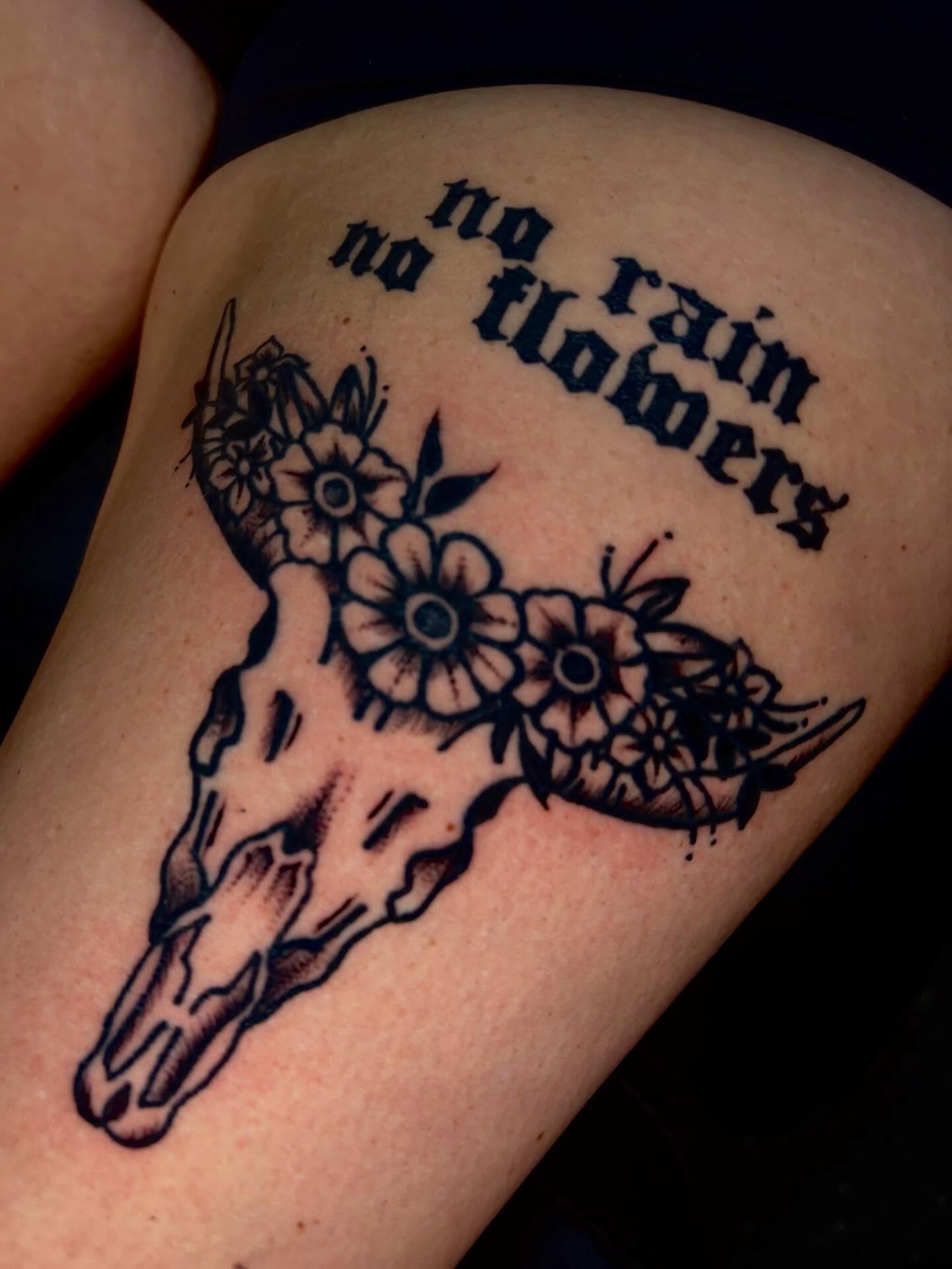 Cow skull with flowers American traditional tattoo on the shoulder by Jenna Clayton