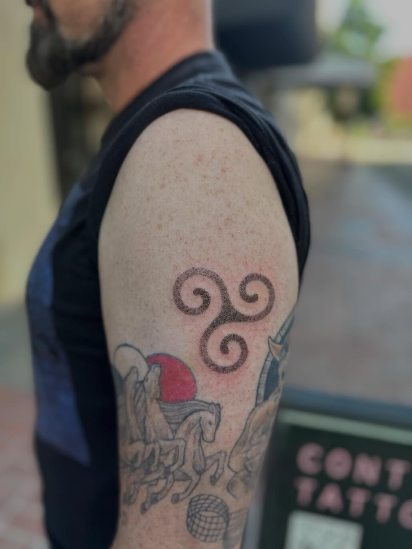 Triskelion black and grey tattoo on the upper arm by Cherry Tats🍒