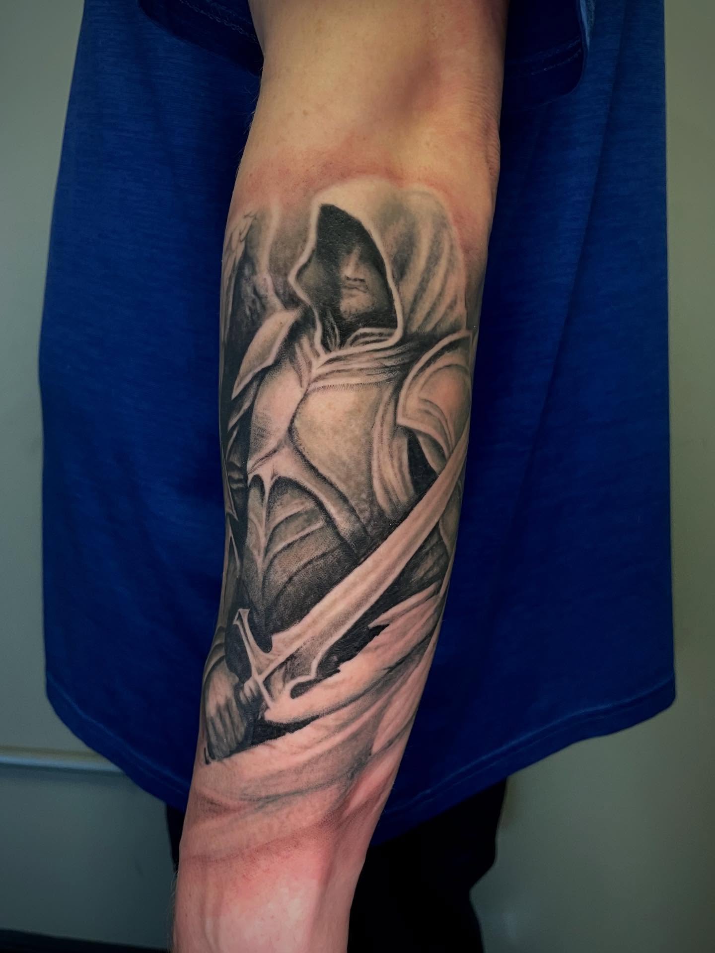 Hooded figure realism tattoo on the forearm by Bryce Presley, Mission, Kansas
