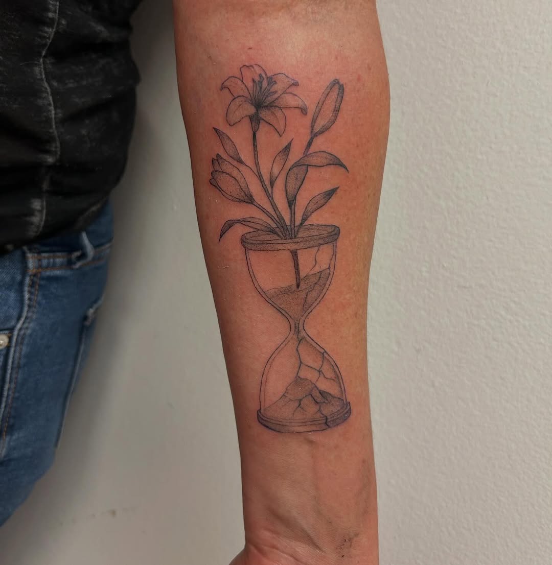Hourglass with flowers fine line tattoo on the forearm by Chris