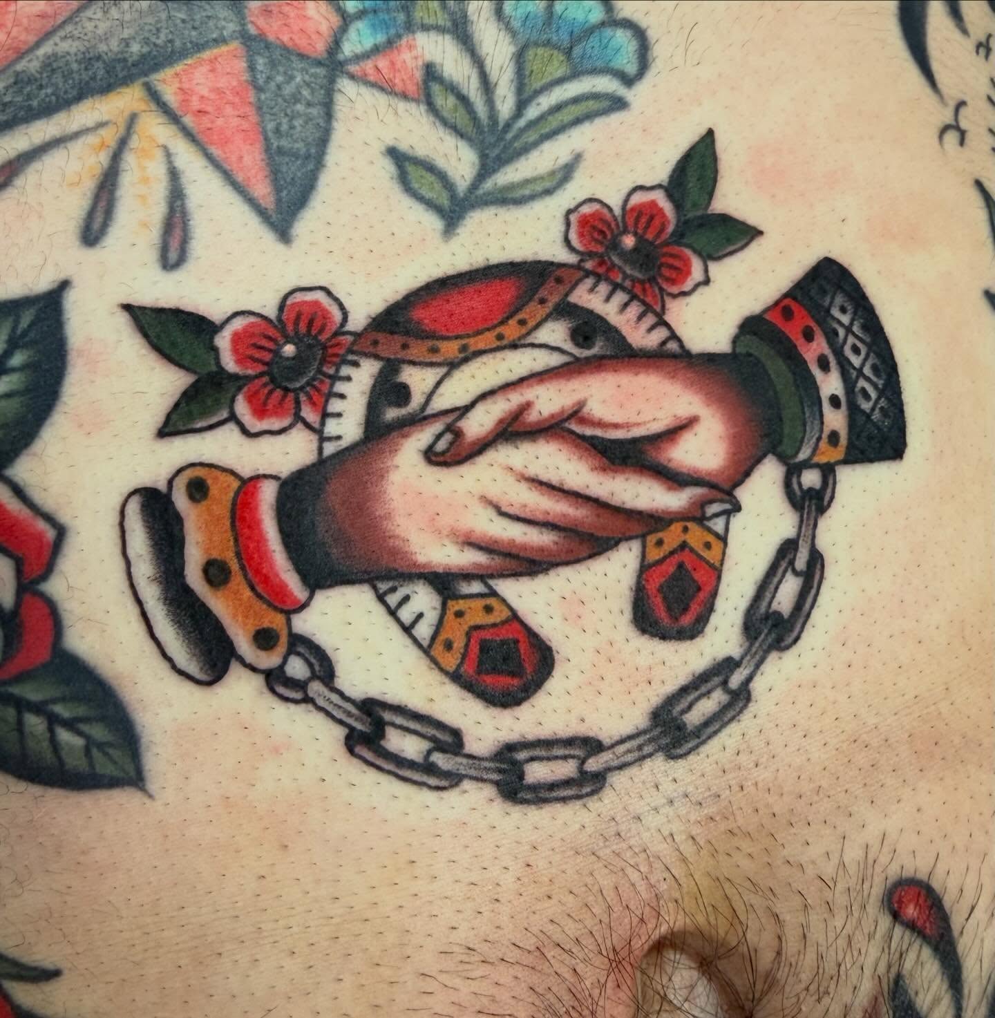 Hands entwined American traditional tattoo on the chest by David Evans