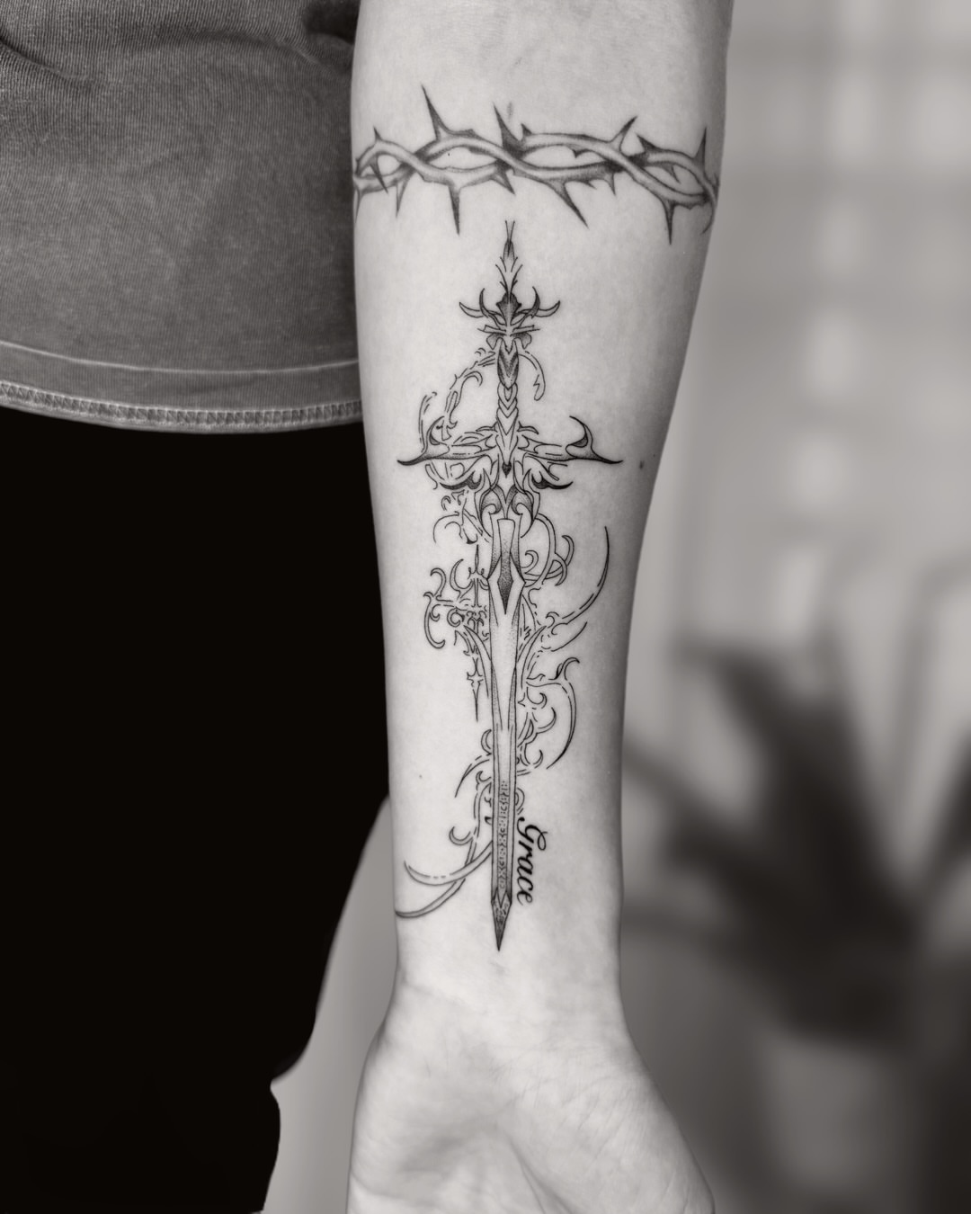Sword and crown ornamental tattoo on the forearm by Ingrid Rojas