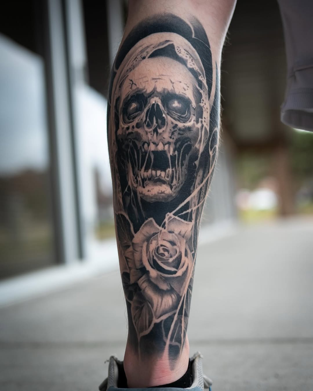 Skull and rose realism tattoo on the calf by Derek Hutchison, Des Moines, Iowa