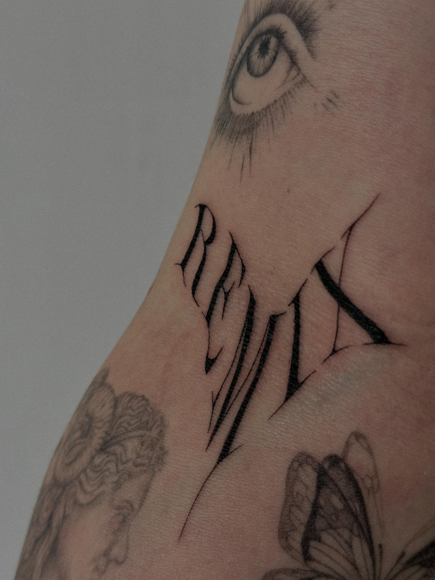 Eye and name realism tattoo on the forearm by Hannah Matthews
