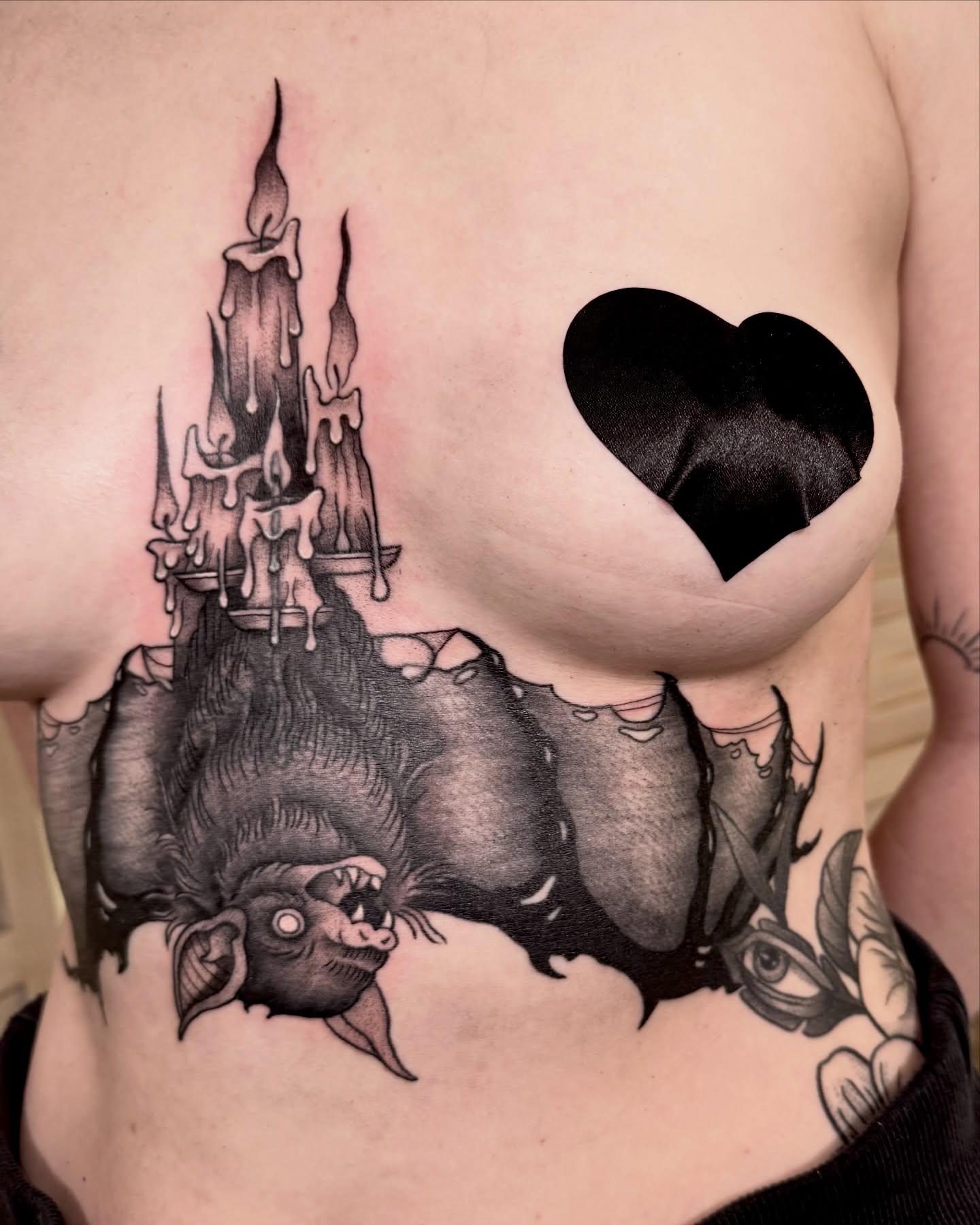 Candle tower and heart dark realism tattoo on the chest by Eden Allen