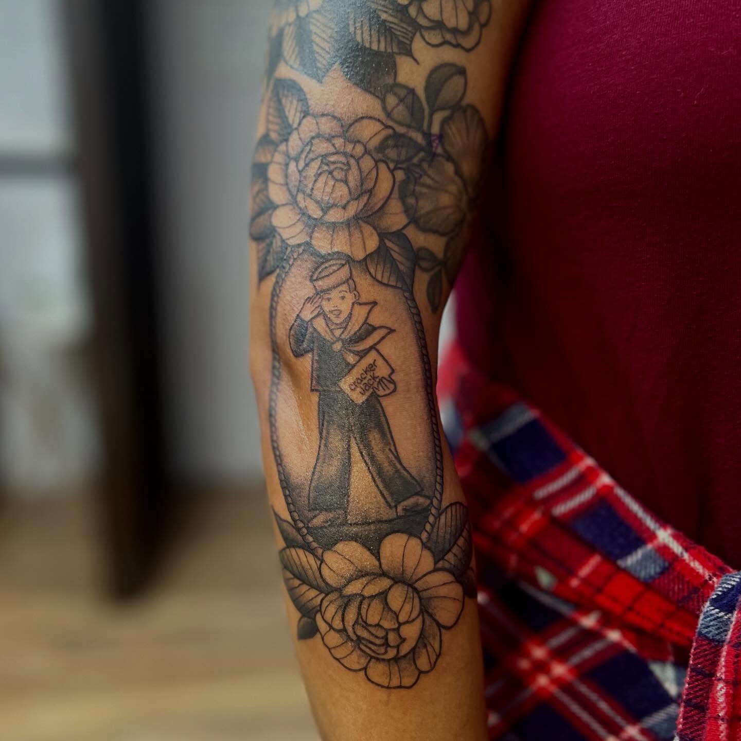 Mailman with flowers black and grey tattoo on the forearm by Victorian Coleman