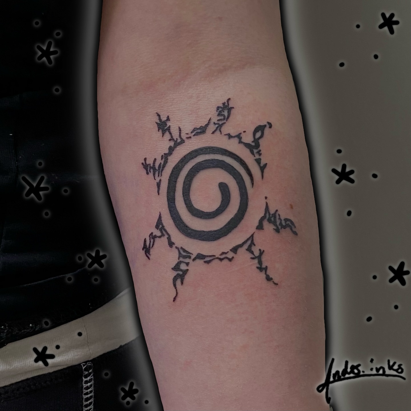 Spiral with bat-like figures black and grey tattoo on the forearm by ande