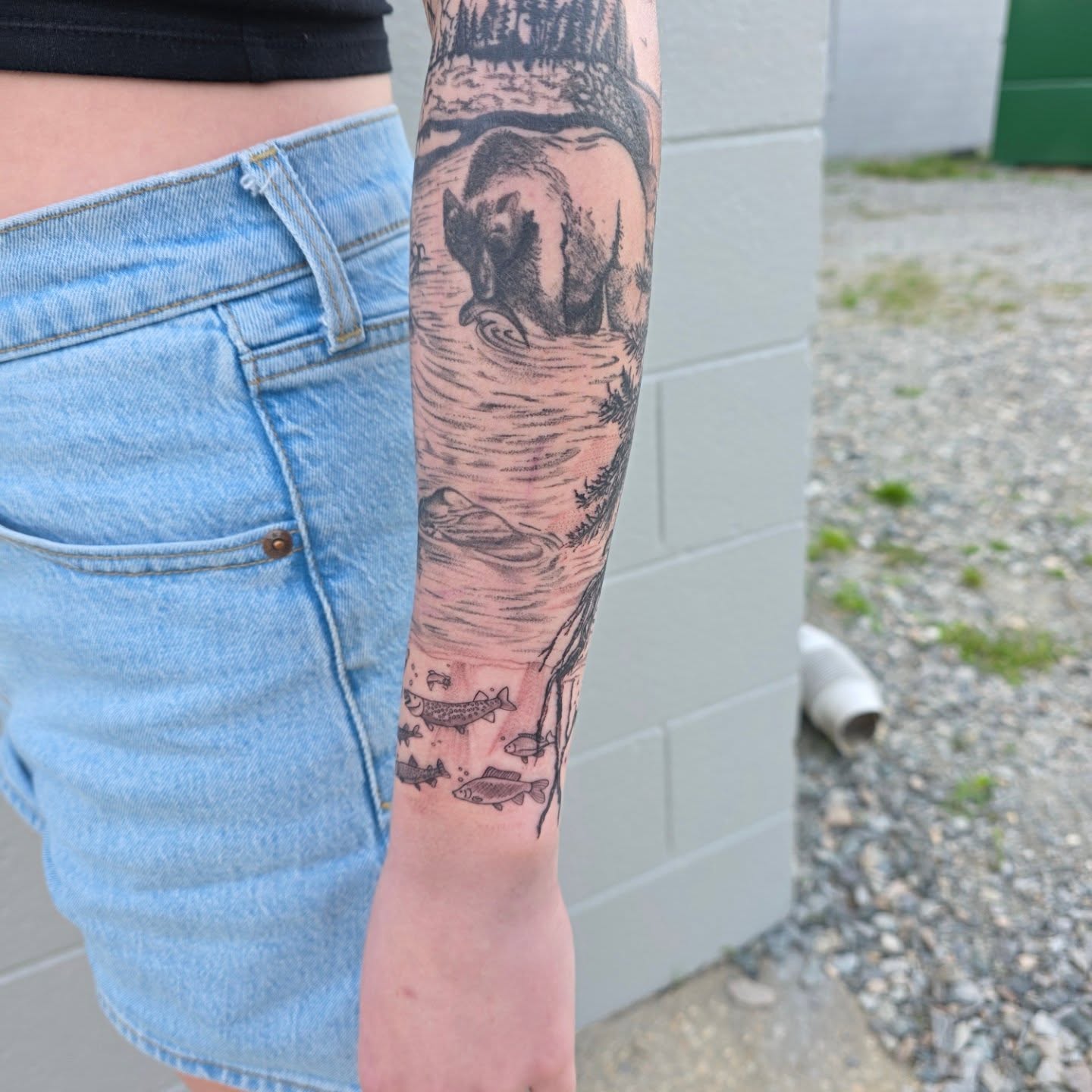 Bear fishing realism tattoo on the forearm by Maggie