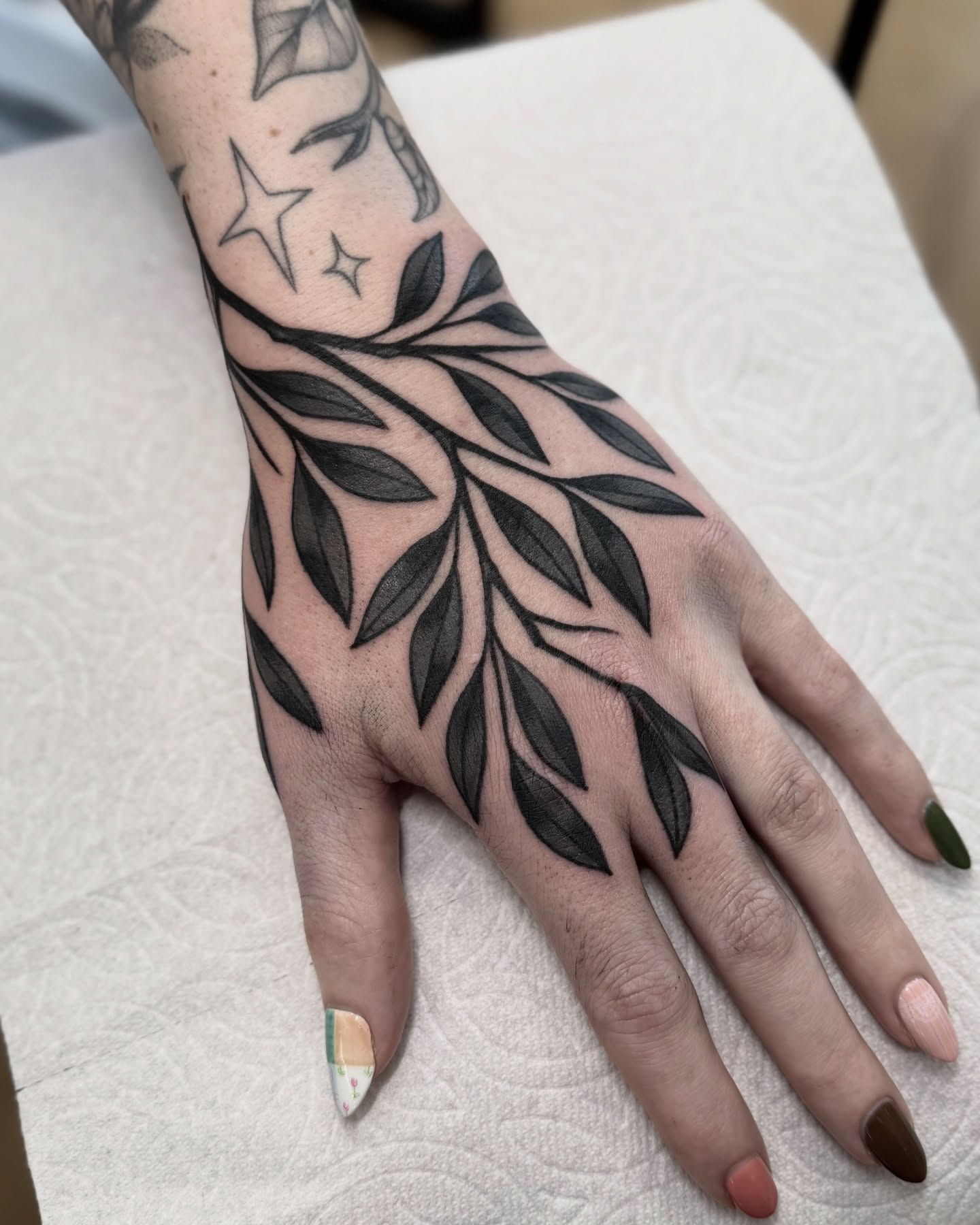 Branch with leaves black and grey tattoo on the hand by Nia (Knee-uhh) 🦷