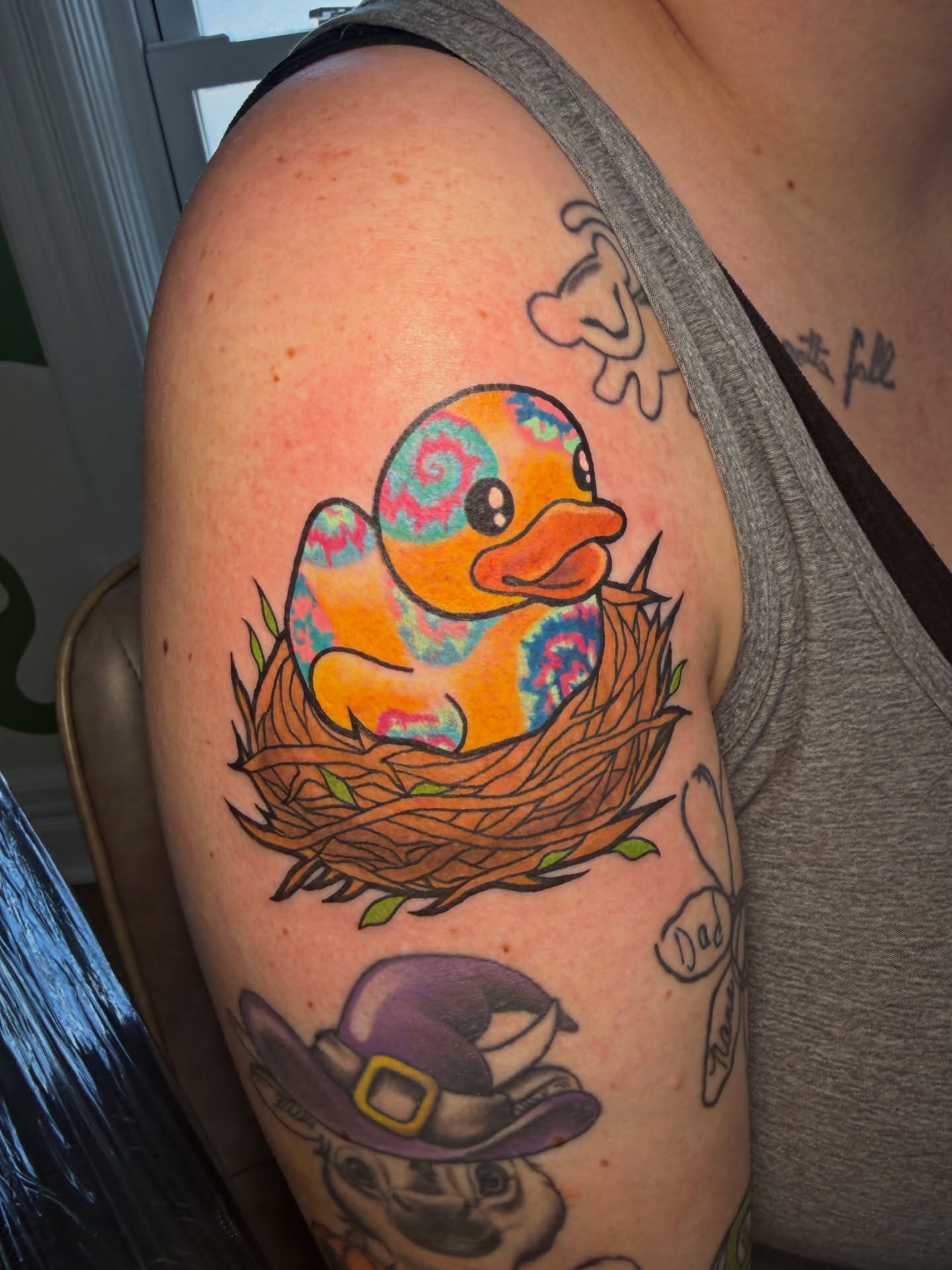 Rubber duck in nest new school tattoo on the shoulder by Lyndze Masters