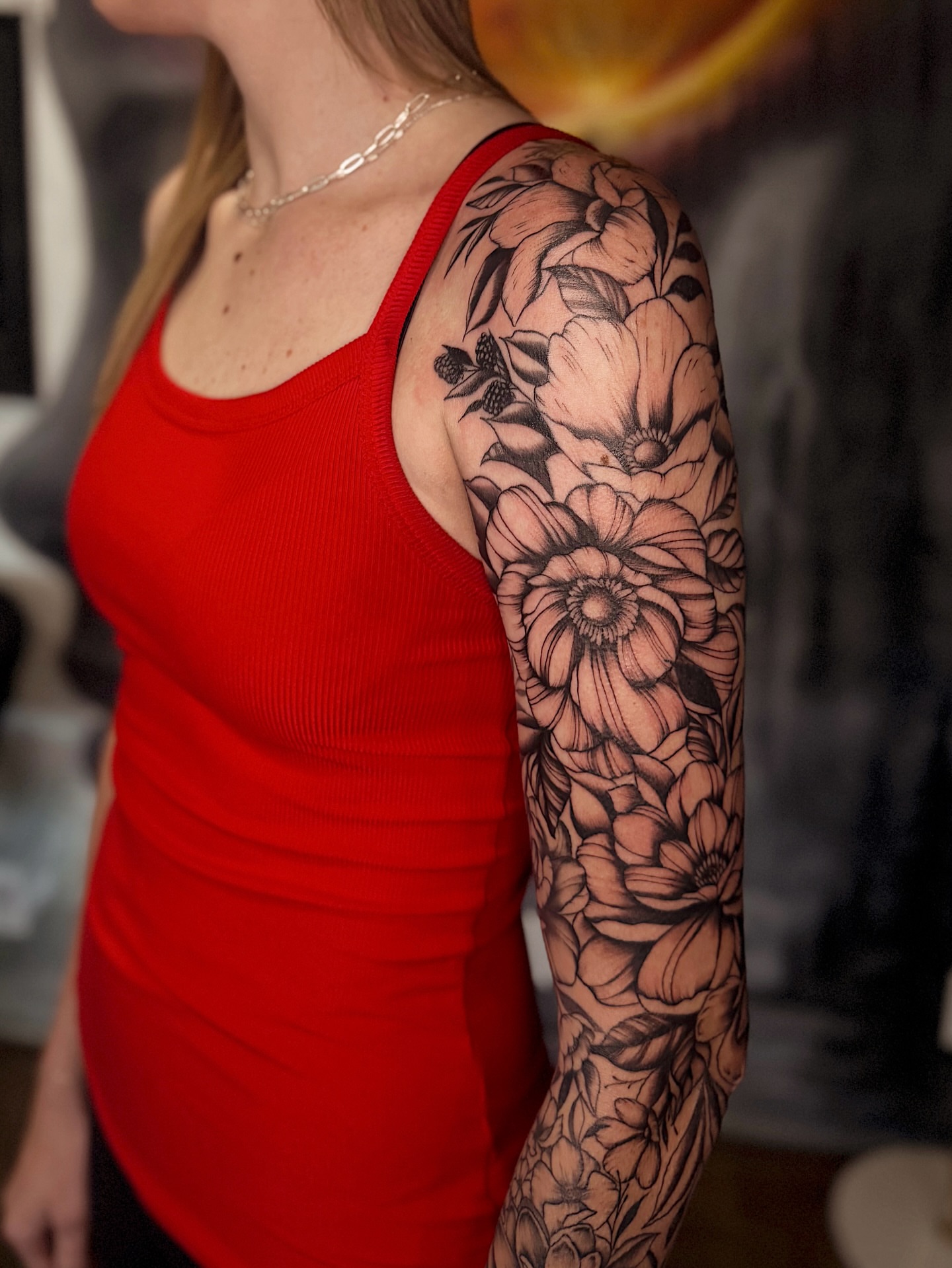 Floral bouquet black and grey tattoo on the upper arm by Breanna Werner