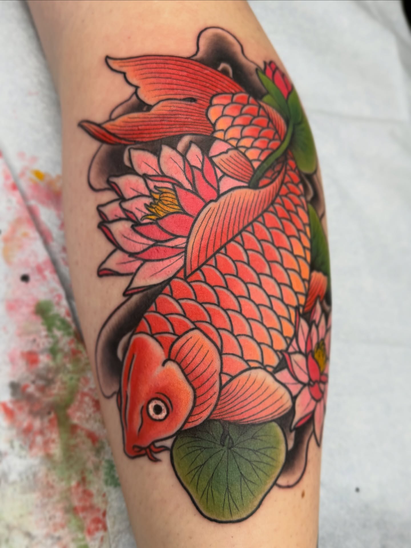 Koi fish and lotus American traditional tattoo on the forearm by Anna Wall