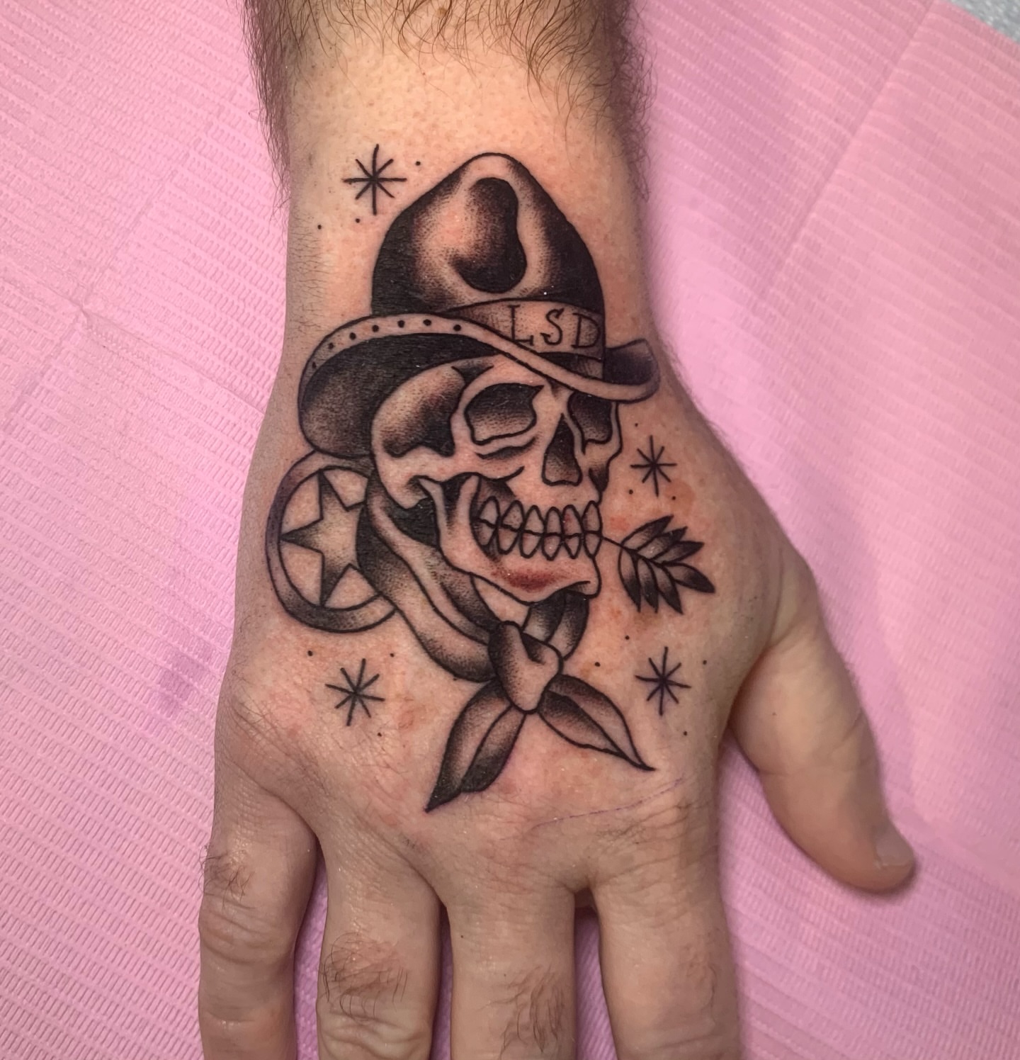 Skull wearing hat black and grey tattoo on the hand by Aubrianna Grisez
